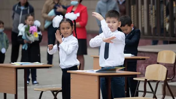 Kazakh students and schoolchildren sit at school desks made in Turkmenistan